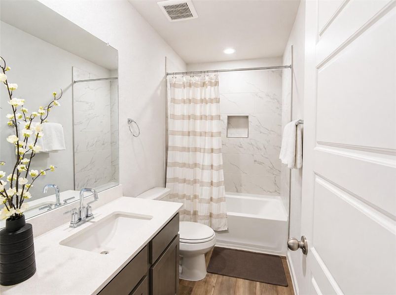 Marble-patterned wall tile and a sleek vanity highlight this clean, modern bathroom design. Marble-patterned wall tile and a sleek vanity highlight this clean, modern bathroom design.