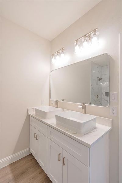 Bathroom featuring hardwood / wood-style floors, vanity, and a shower