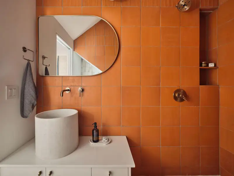 Bathroom featuring tiled shower, tile walls, and vanity Bathroom featuring tiled shower, tile walls, and vanity