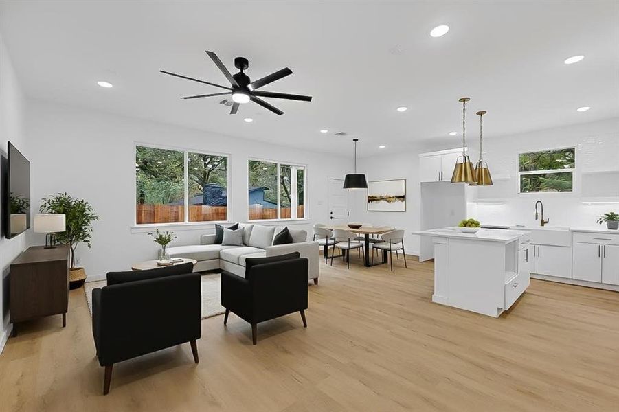 Living room featuring light wood-style floors, recessed lighting, and a ceiling fan Living room featuring light wood-style floors, recessed lighting, and a ceiling fan