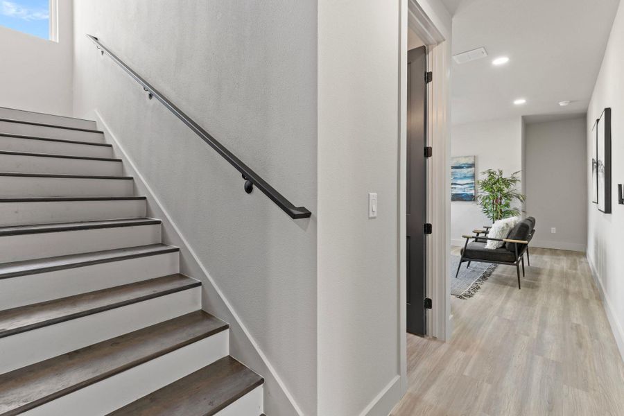 Stairs with recessed lighting, wood finished floors, and baseboards