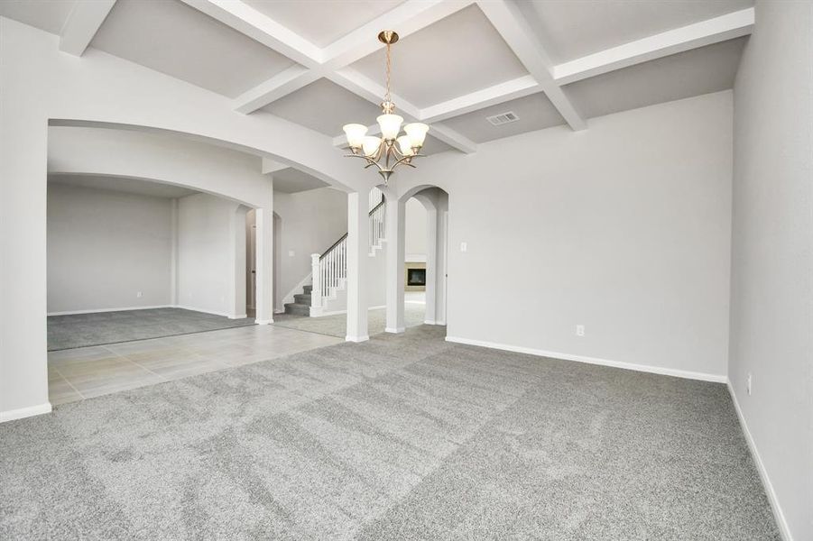 The dining room features plush carpet, high ceilings with beams, chandelier, and large windows.