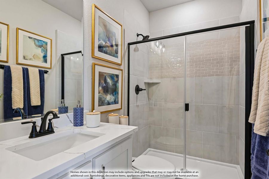 Bathroom with white vanity, black fixtures, glass-enclosed tile shower, and framed wall art Bathroom with white vanity, black fixtures, glass-enclosed tile shower, and framed wall art