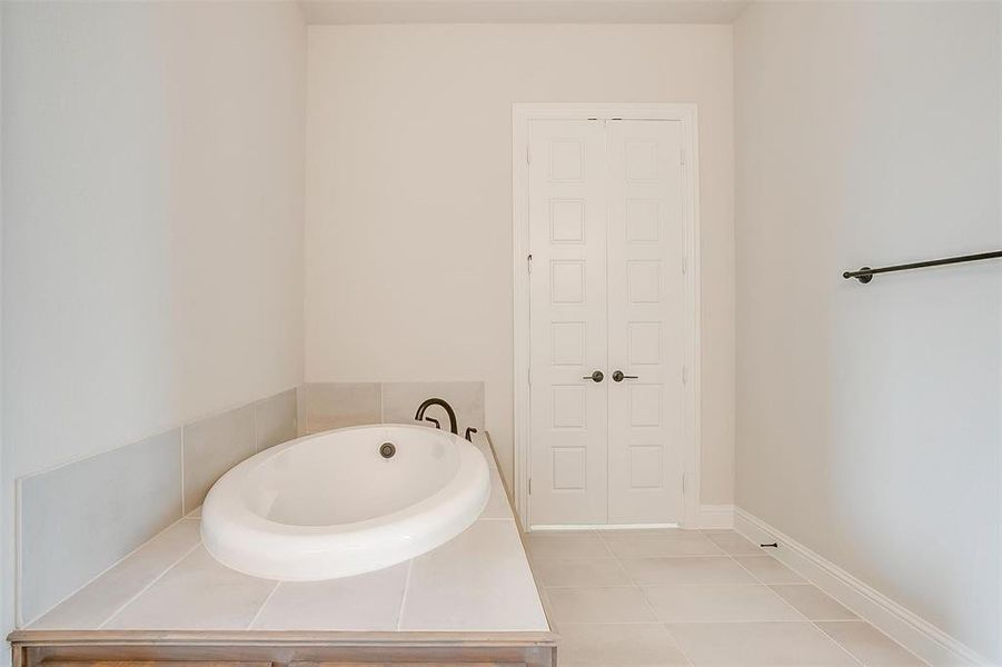 Bathroom with a tub to relax in and tile patterned floors