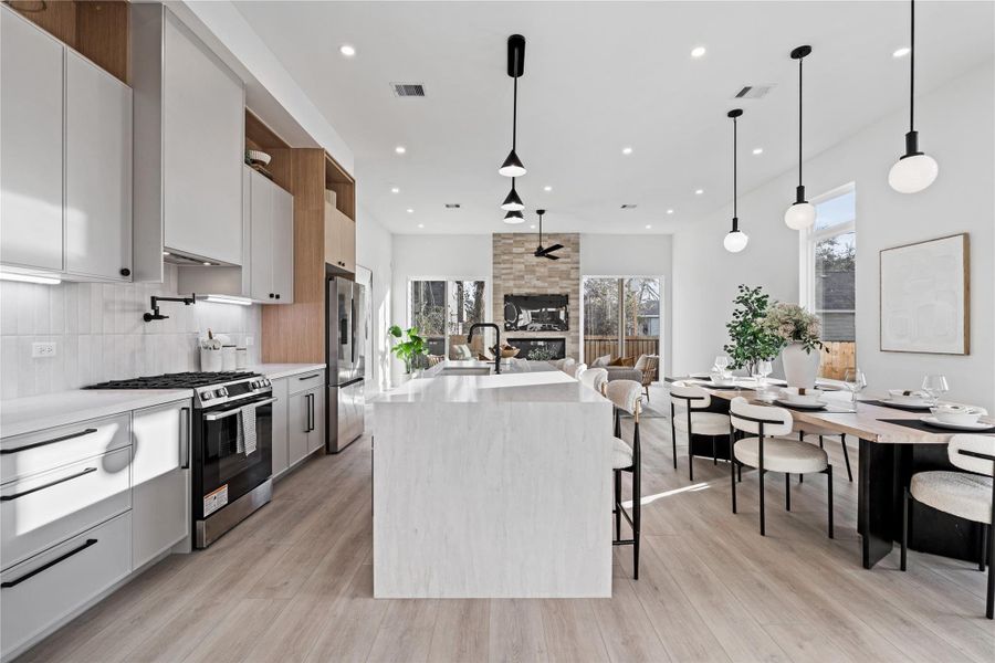 Soaring ceilings and curated materials define this seamless living space, where kitchen, dining, and family room unfold in harmony. It’s a setting designed for connection, comfort, and elevated daily living.