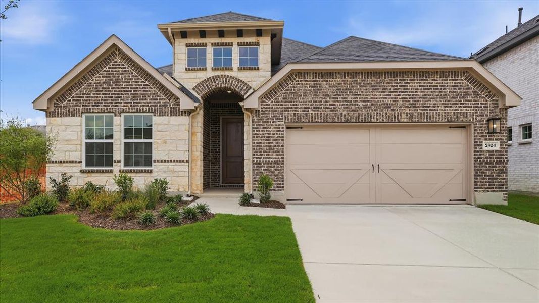 Brick and stone exterior featuring an arched entryway, decorative garage door, dormer window, and established landscaping Brick and stone exterior featuring an arched entryway, decorative garage door, dormer window, and established landscaping