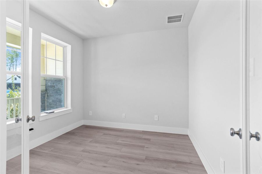 The study provides the quiet retreat necessary for a productive home office, eliminating the daily commute and maximizing work-from-home efficiency. It features French doors, neutral toned walls, and large windows.