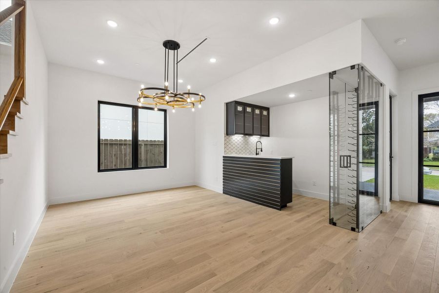 A large fixed pane window opens up the formal Dining to create a warmly lit environment to entertain your guests. The bar area has storage above and below.
