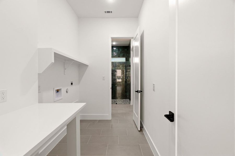 Laundry area featuring hookup for a washing machine, light tile patterned flooring, and electric dryer hookup