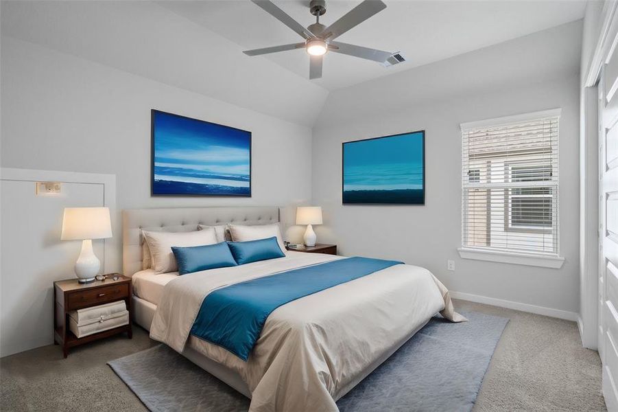 Secondary bedroom features plush carpet, custom paint, ceiling fan with lighting and a large window with privacy blinds.