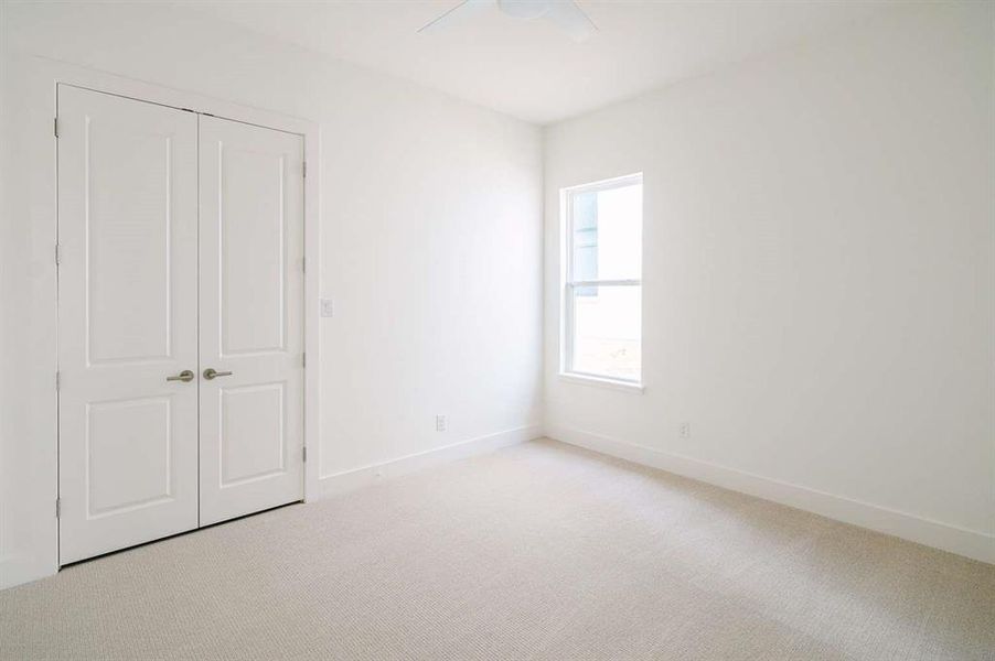 Unfurnished bedroom with ceiling fan, light carpet, and a closet