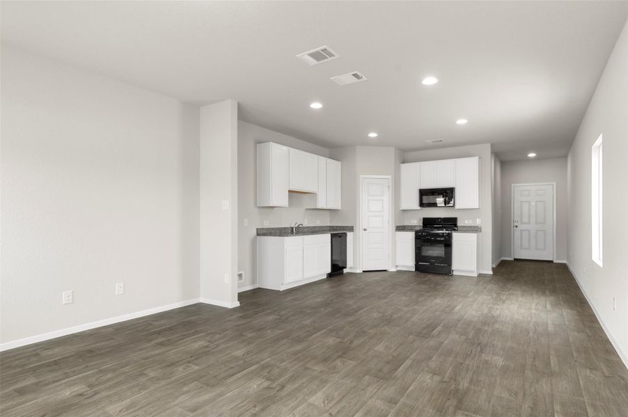 Kitchen featuring black appliances, dark wood finished floors, recessed lighting, and white cabinetry Kitchen featuring black appliances, dark wood finished floors, recessed lighting, and white cabinetry