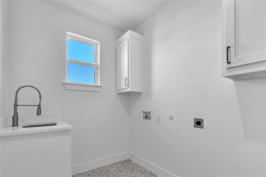 Laundry room with sink, hookup for an electric dryer, hookup for an electric dryer, cabinets, and hookup for a washing machine Laundry room with sink, hookup for an electric dryer, hookup for an electric dryer, cabinets, and hookup for a washing machine