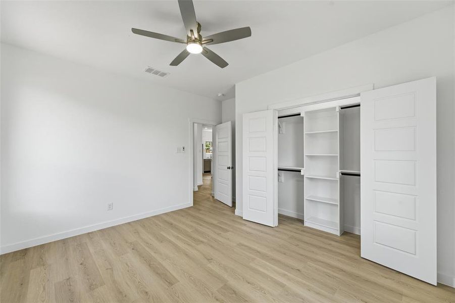 Room featuring light wood-finish flooring, white walls, and a contemporary ceiling fan with integrated lighting