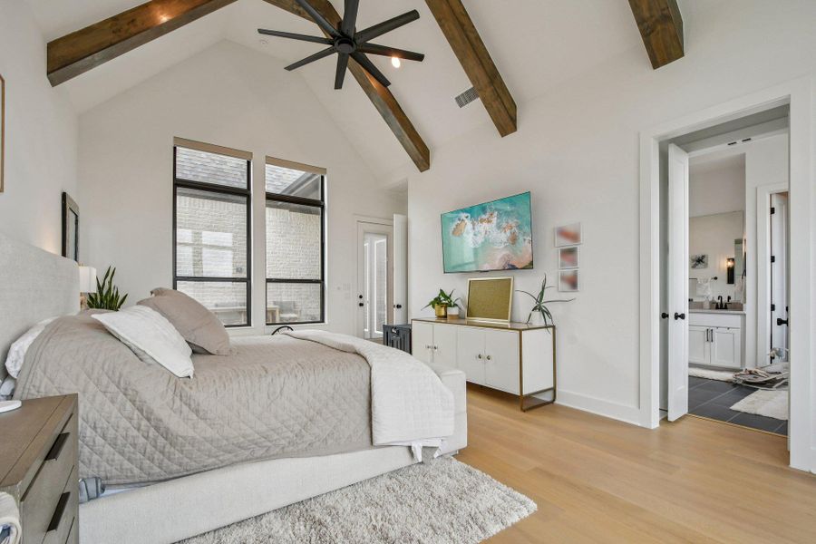 This spacious room features a vaulted ceiling with exposed wooden beams, light-colored hardwood flooring, and large windows providing natural light This spacious room features a vaulted ceiling with exposed wooden beams, light-colored hardwood flooring, and large windows providing natural light