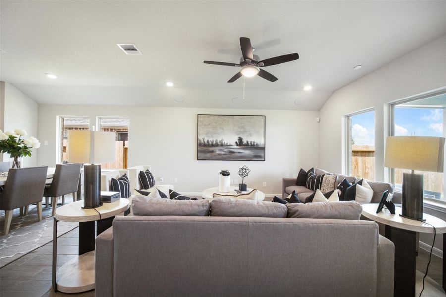 Gather the family and guests together in your lovely living room! Featuring soaring high ceilings, recessed lighting, ceiling fan, custom paint, gorgeous floors, and large windows that provide plenty of natural lighting throughout the day. Sample photo of completed home with similar floor plan. Actual colors and selections may vary.