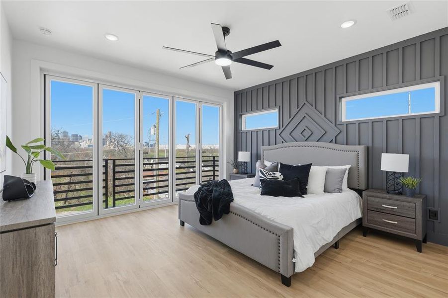 Bedroom with light wood-type flooring, ceiling fan, recessed lighting, and an accent wall
