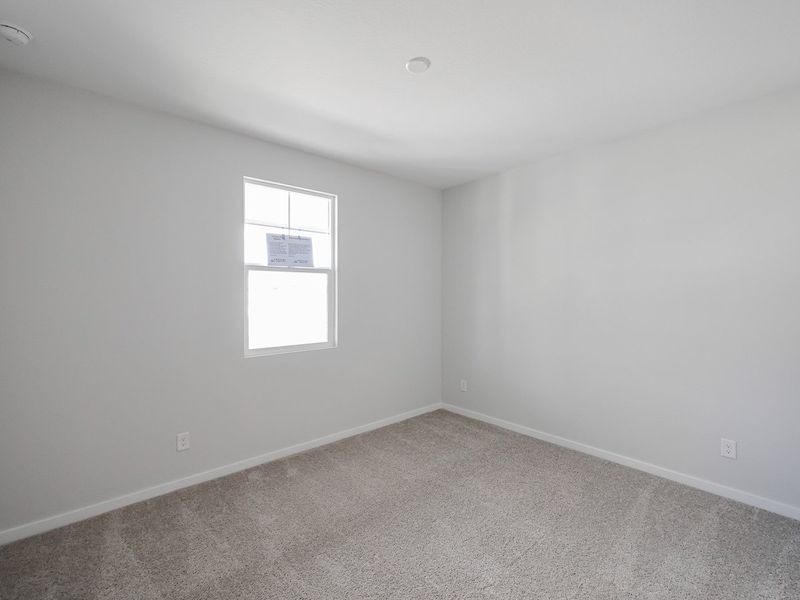 A room with a window and a carpet.