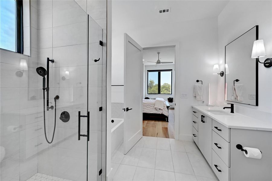 Full bathroom with ensuite bathroom, a shower stall, vanity, a ceiling fan, and visible vents Full bathroom with ensuite bathroom, a shower stall, vanity, a ceiling fan, and visible vents