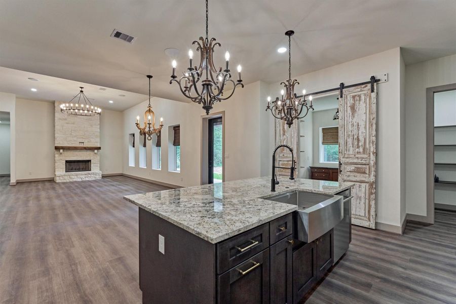The impressive 8 ft. island complete with farmhouse sink, provides ample space for meal preparation while simultaneously entertaining guests