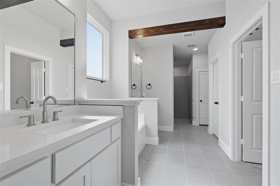 Bathroom with light tile patterned flooring, two vanities, and a bath Bathroom with light tile patterned flooring, two vanities, and a bath