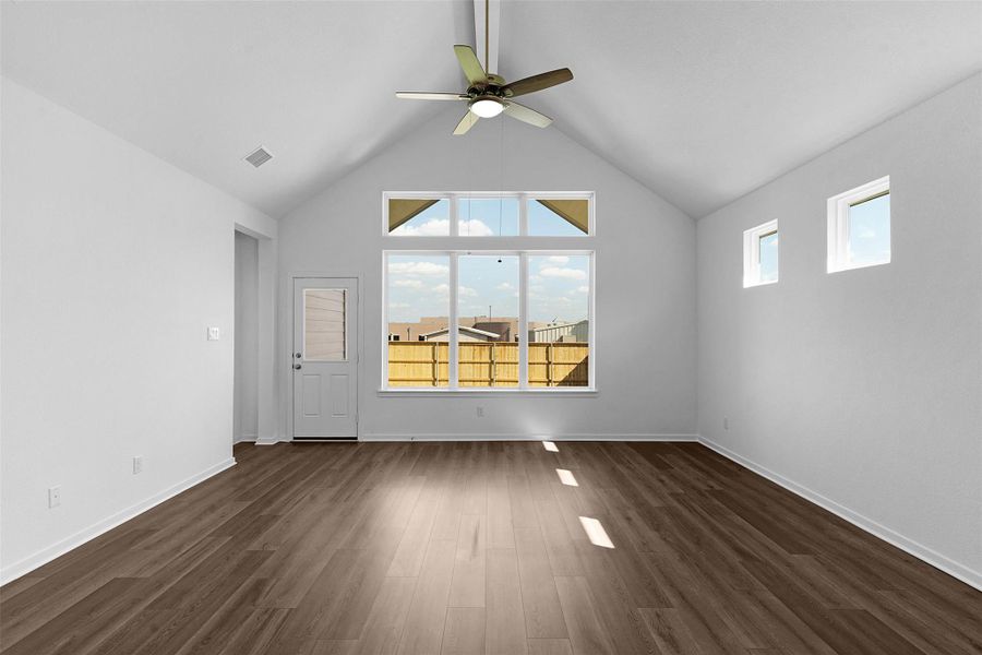Unfurnished living room featuring dark wood-style flooring, ceiling fan, and high vaulted ceiling