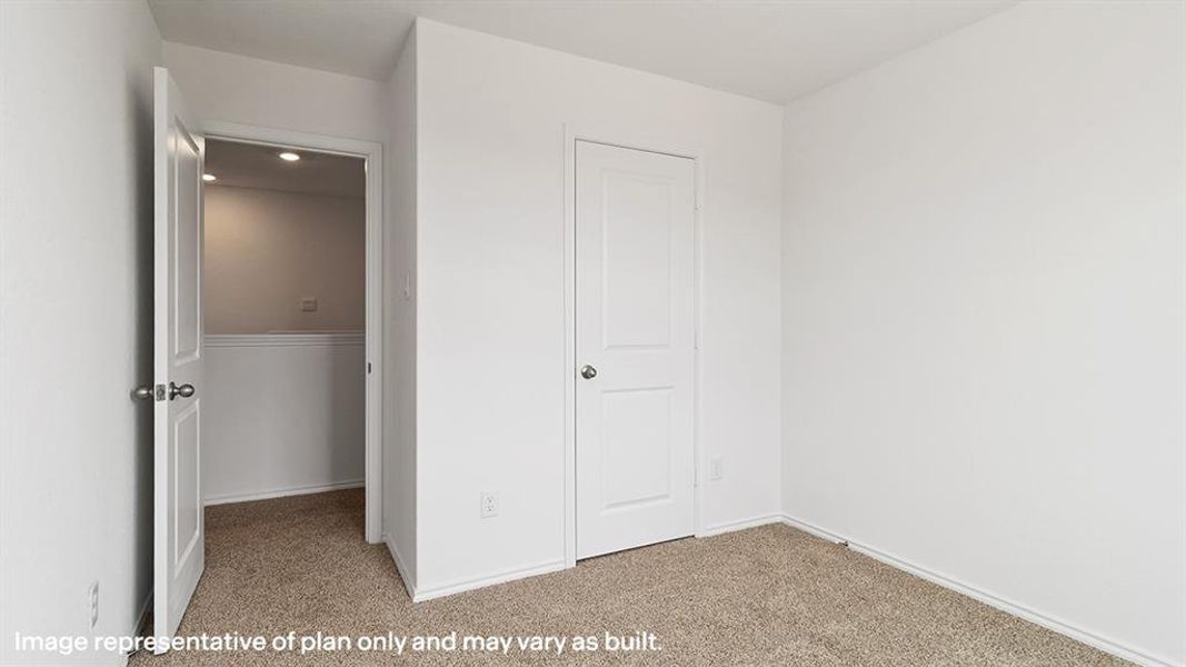 Unfurnished bedroom with light carpet and baseboards