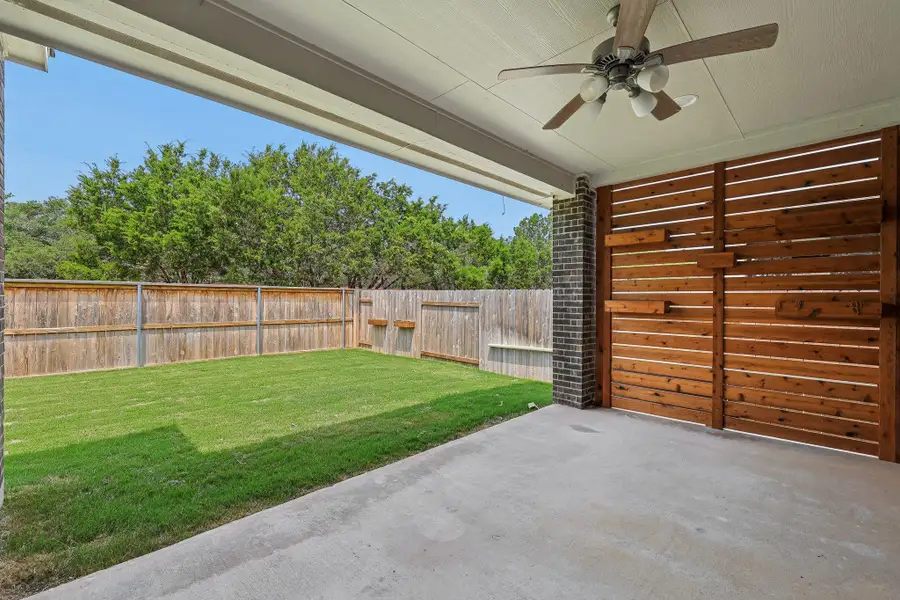 View of yard with a ceiling fan and a patio area View of yard with a ceiling fan and a patio area