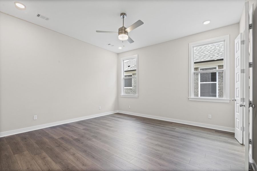 Empty room featuring plenty of natural light, wood-type flooring, recessed lighting, and a ceiling fan