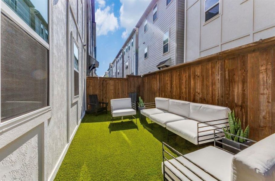 Fenced side yard featuring artificial turf and board on board fence
