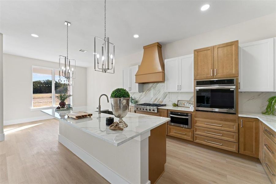 Kitchen with brown cabinets, light stone counters, appliances with stainless steel finishes, tasteful backsplash, and pendant lighting Kitchen with brown cabinets, light stone counters, appliances with stainless steel finishes, tasteful backsplash, and pendant lighting