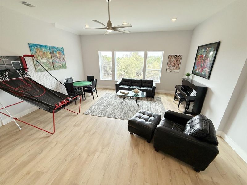 Living room featuring light wood-style flooring, ceiling fan, and recessed lighting