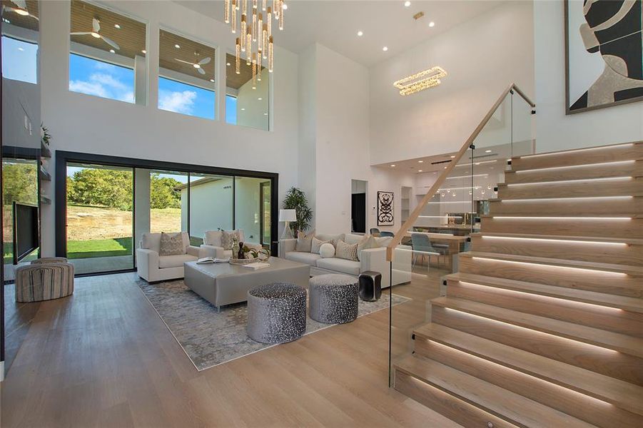 Living room with a notable chandelier, a towering ceiling, and wood-type flooring