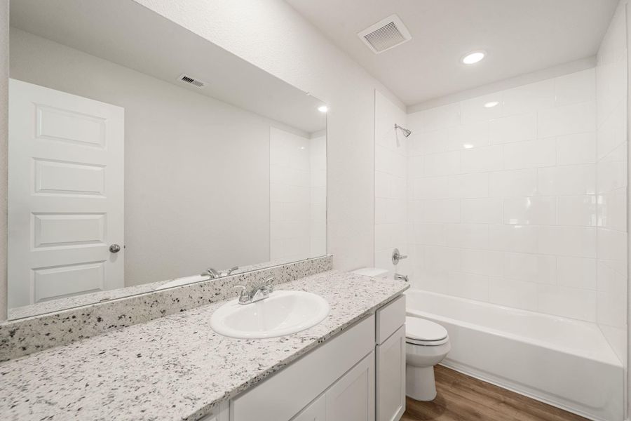 A sleek full bathroom showcasing a dual-sink vanity with granite countertops, ample storage, and a clean, modern design with a combination tub and shower. A sleek full bathroom showcasing a dual-sink vanity with granite countertops, ample storage, and a clean, modern design with a combination tub and shower.