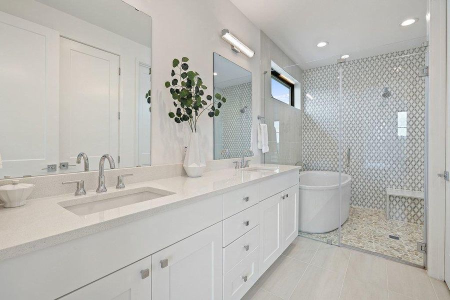 Bathroom featuring a dual vanity with integrated sinks, white cabinetry, and polished chrome fixtures