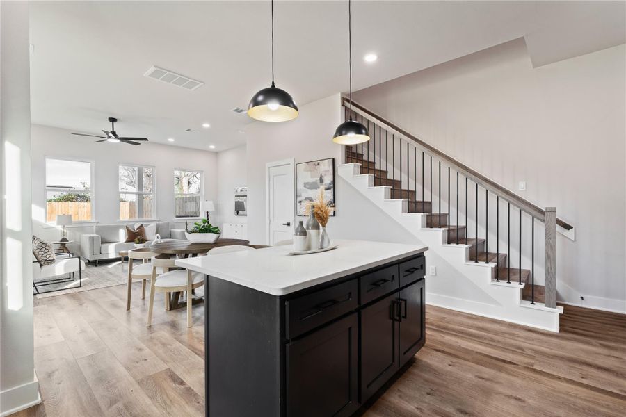 The heart of the home shines with a large island and an open layout that connects every space with ease. With soaring ceilings, designer lighting, and a smooth flow into the living area, this home feels both elevated and comfortable.