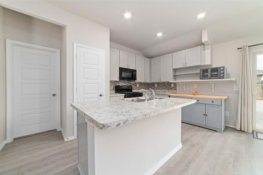 Spacious kitchen with an oversized island and high ceilings, seamlessly connecting to the surrounding living spaces.