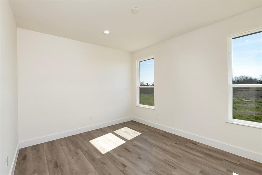Unfurnished room featuring baseboards, wood finished floors, and recessed lighting