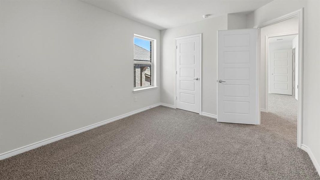 Unfurnished bedroom featuring carpet flooring and baseboards