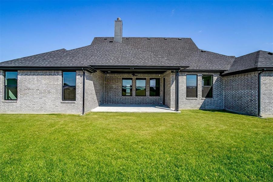 Back of house with a patio area and a lawn