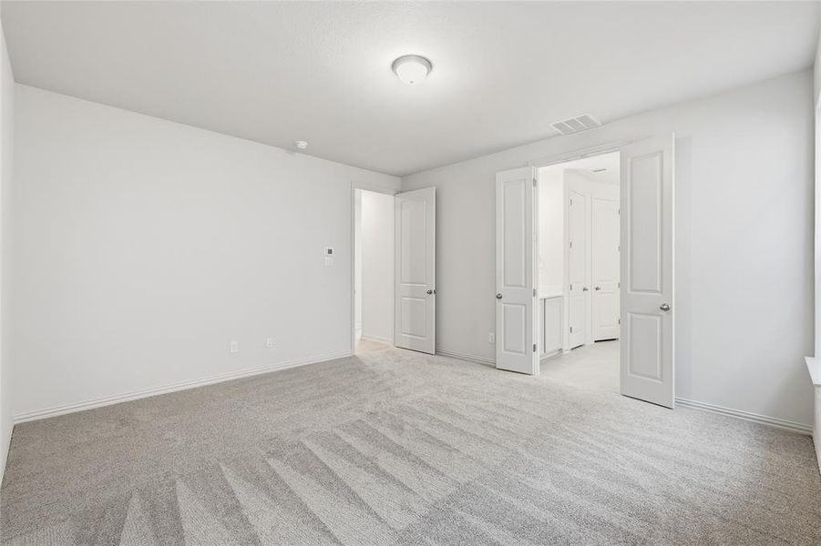 Unfurnished bedroom featuring light colored carpet and baseboards