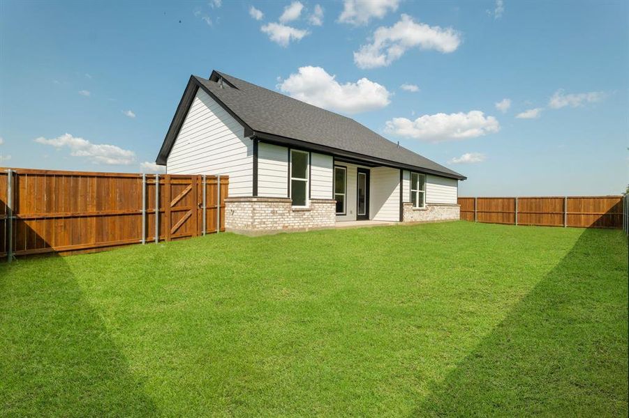 Rear view of house featuring a yard
