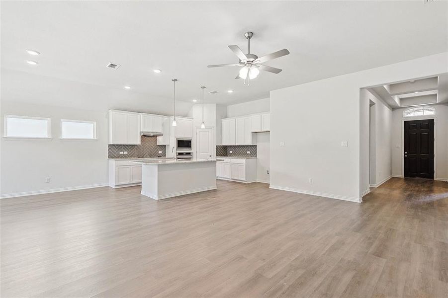 Kitchen with white cabinets, light wood-type flooring, and a kitchen island