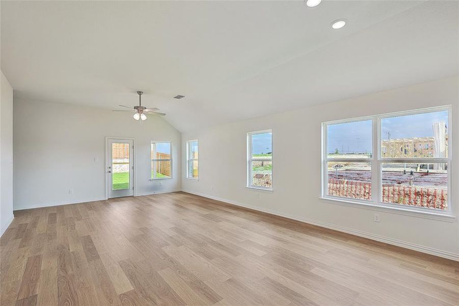 Spare room featuring vaulted ceiling, ceiling fan, and light hardwood / wood-style flooring