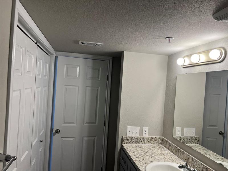 Bathroom featuring vanity and a textured ceiling