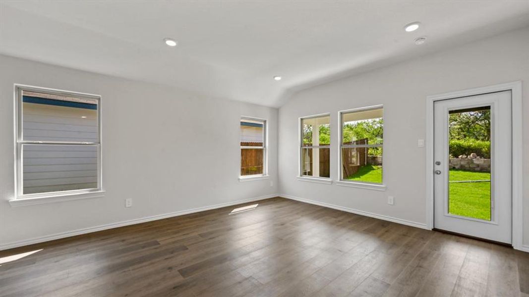 Spacious room featuring wood-finish flooring, recessed lighting, and multiple windows