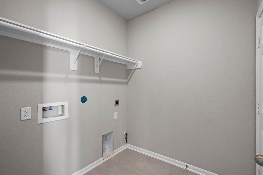 The laundry room layout is carefully planned for optimal workflow with designated areas for washing, drying, and storing.