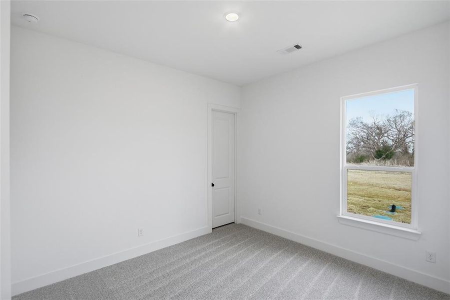 Unfurnished room featuring baseboards and light carpet