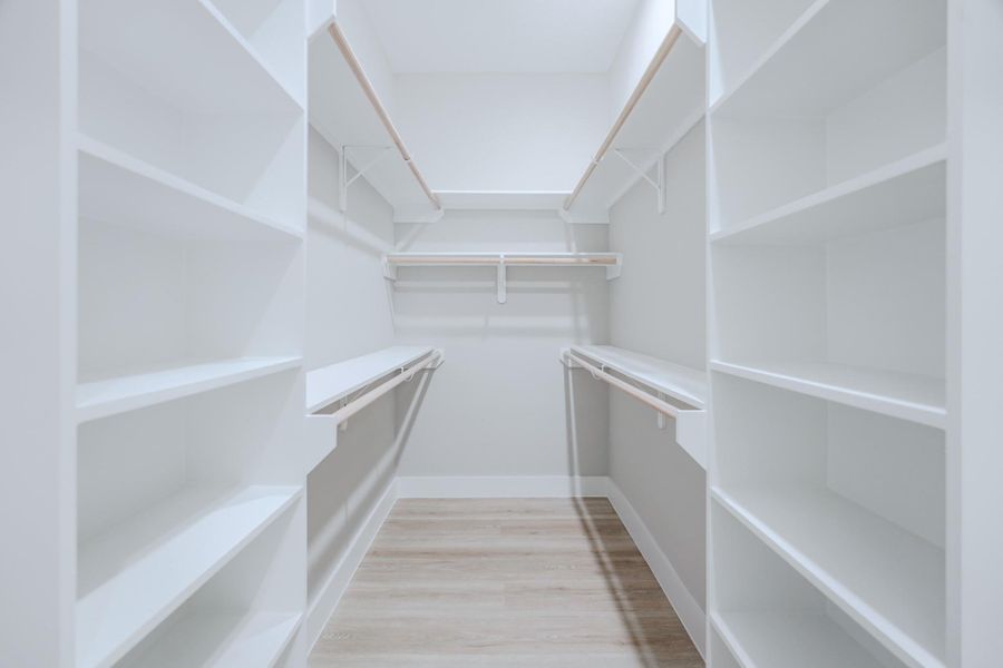Expansive walk-in closet offers custom storage solutions in primary suite
