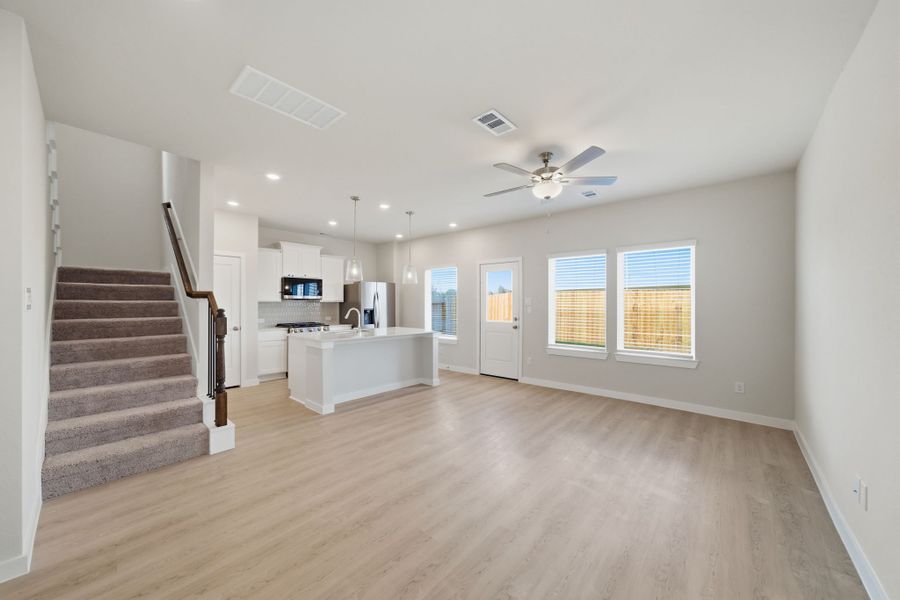 A large empty room with a wood floor and a white counter.